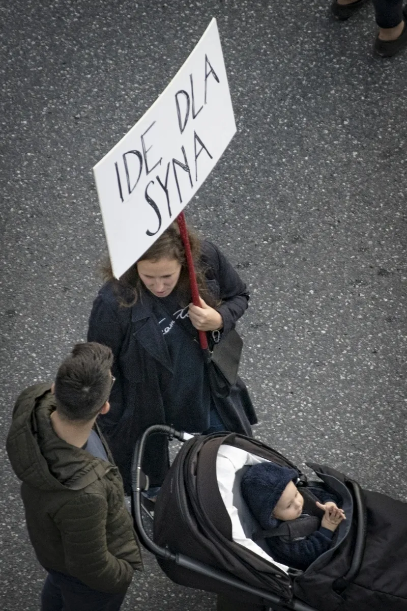 Protester pushing a stroller and holding an IDE DLA SYNA sign